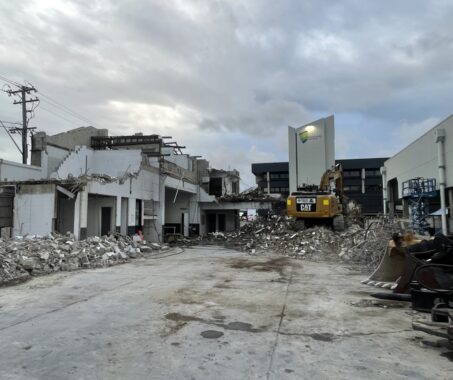 Demolition in progress at residential and commercial site with heavy machinery operated by Razor Asbestos in Queensland.