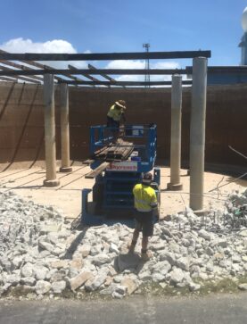 Industrial tank demolition in progress using elevated platform and hand tools