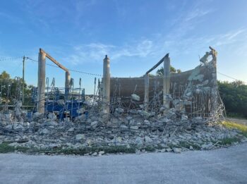 Partially demolished Mt Basset Water Reservoir showing exposed rebar and concrete rubble during active demolition