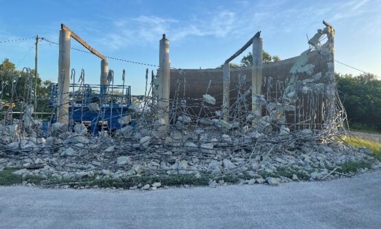 Partially demolished Mt Basset Water Reservoir showing exposed rebar and concrete rubble during active demolition