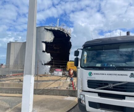 Razor Asbestos demolition truck at an industrial asbestos removal site in Queensland, showing large-scale structure deconstruction in progress.
